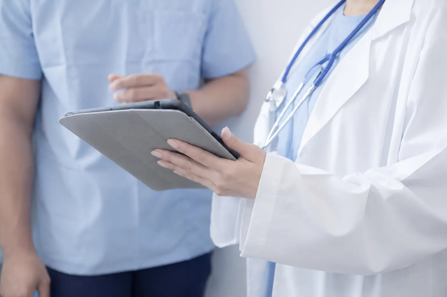 Equipe medica e chirurgo specialista durante un consulto con tablet in clinica a Roma